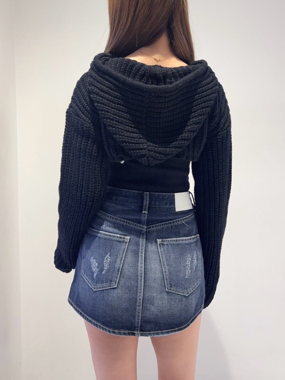 ブラック系のブーツ、ブルー系のデニムスカート、ブラック系のニット/セーターを着用したレディースの秋コーディネートの5枚目の写真