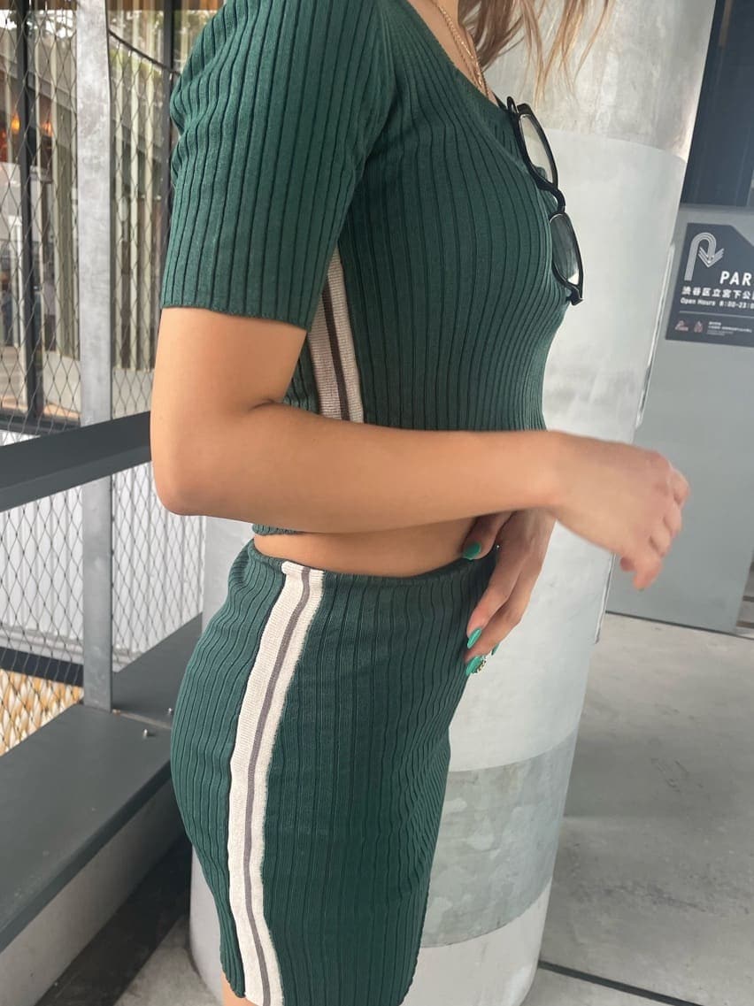 グリーン系のスカート、グリーン系のニット/セーター、ブラック系のサンダルを着用したレディースの夏コーディネートの7枚目の写真