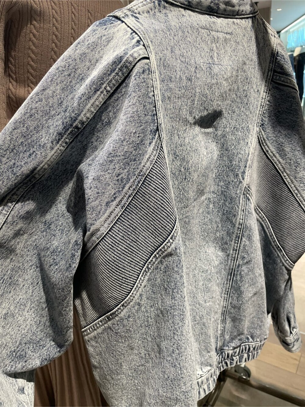 ブルー系のブルゾン、ブラック系のブーツ、ブラック系のニット/セーターを着用したレディースの冬コーディネートの5枚目の写真