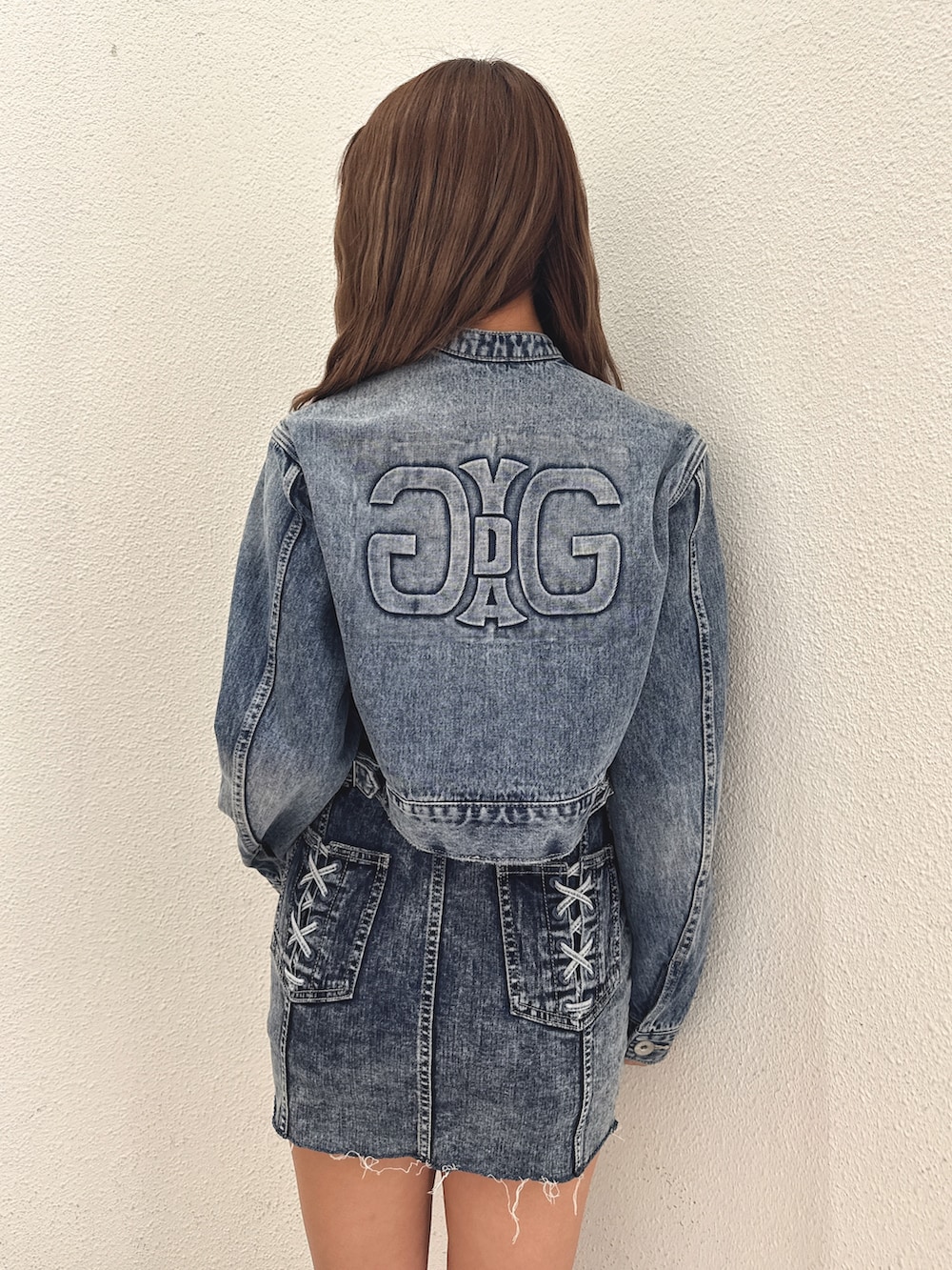 ブルー系のデニムジャケット、ブルー系のワンピース、ホワイト系のブーツを着用したレディースの春コーディネートの6枚目の写真