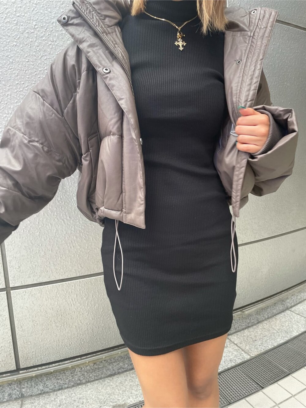 ベージュ系のダウンジャケット/コート、ブラック系のブーツ、ブラック系のワンピースを着用したレディースの秋コーディネートの5枚目の写真