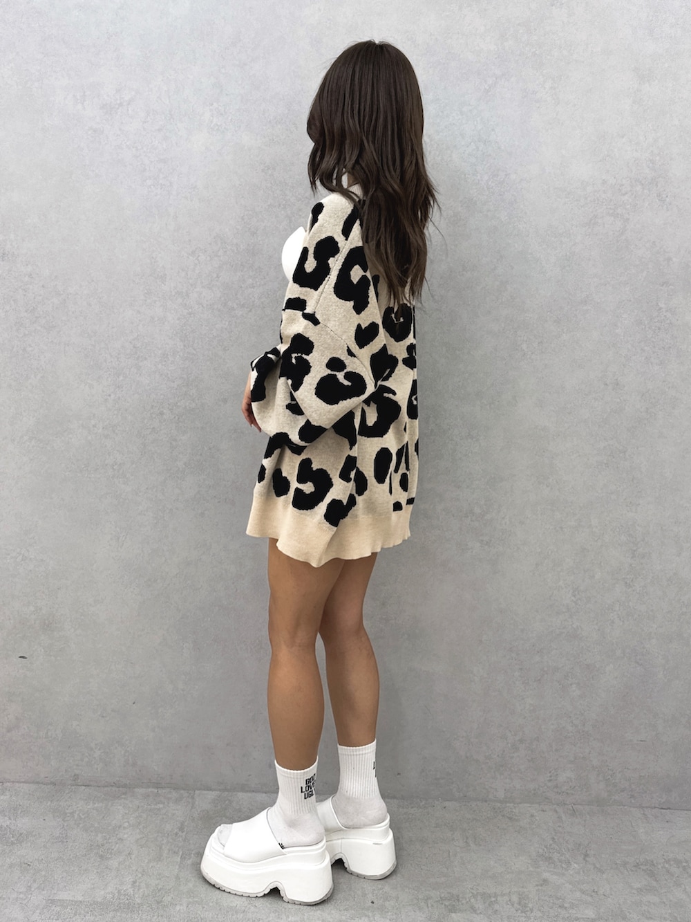 ホワイト系のチューブトップ、ベージュ系のカーディガン/ボレロ、ブルー系のデニムパンツを着用したレディースの夏コーディネートの3枚目の写真