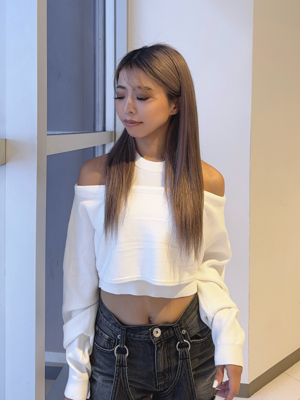 ホワイト系のアンサンブル、ブラック系のデニムパンツ、ホワイト系のパンプスを着用したレディースの秋コーディネートの6枚目の写真