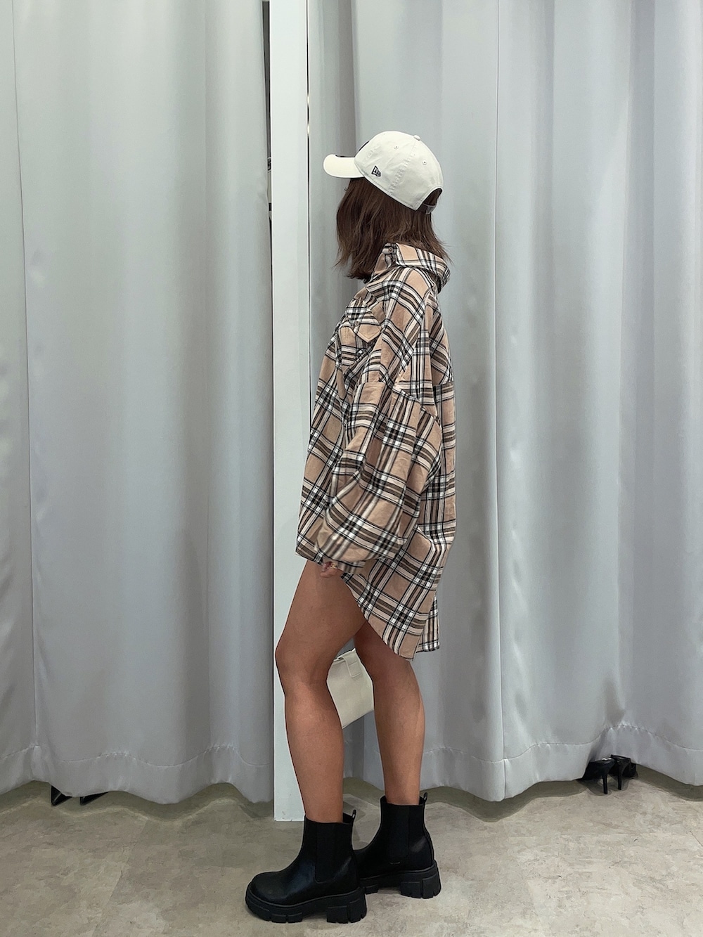 ベージュ系のシャツ/ブラウス、ホワイト系のハンドバッグ、ブラック系のブーツを着用したレディースの春コーディネートの5枚目の写真