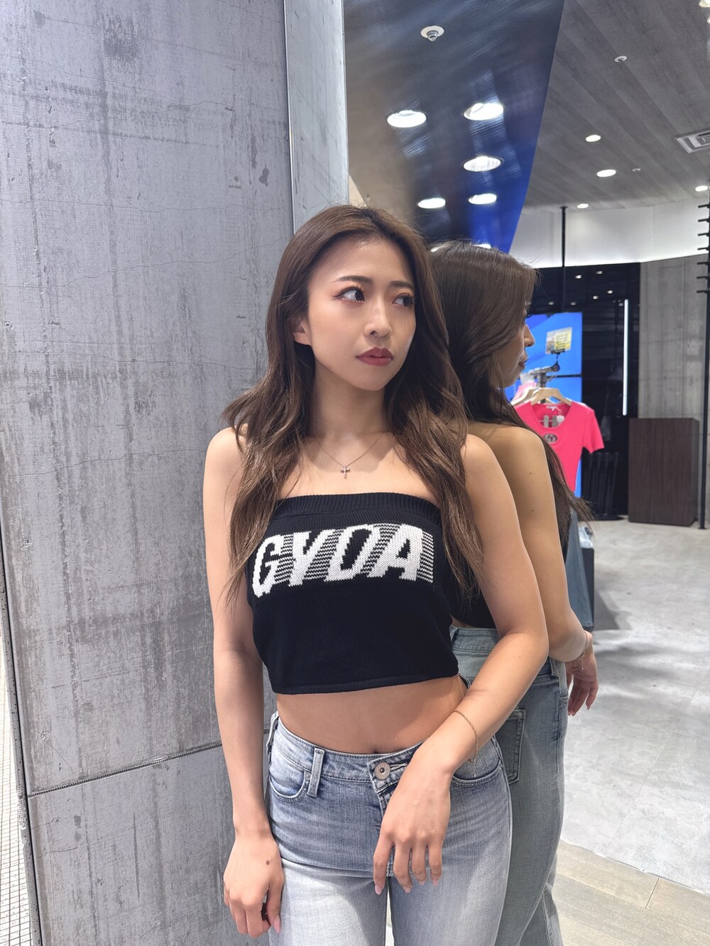 ホワイト系のニット/セーター、ブルー系のデニムパンツ、ホワイト系のサンダルを着用したレディースの夏コーディネートの4枚目の写真