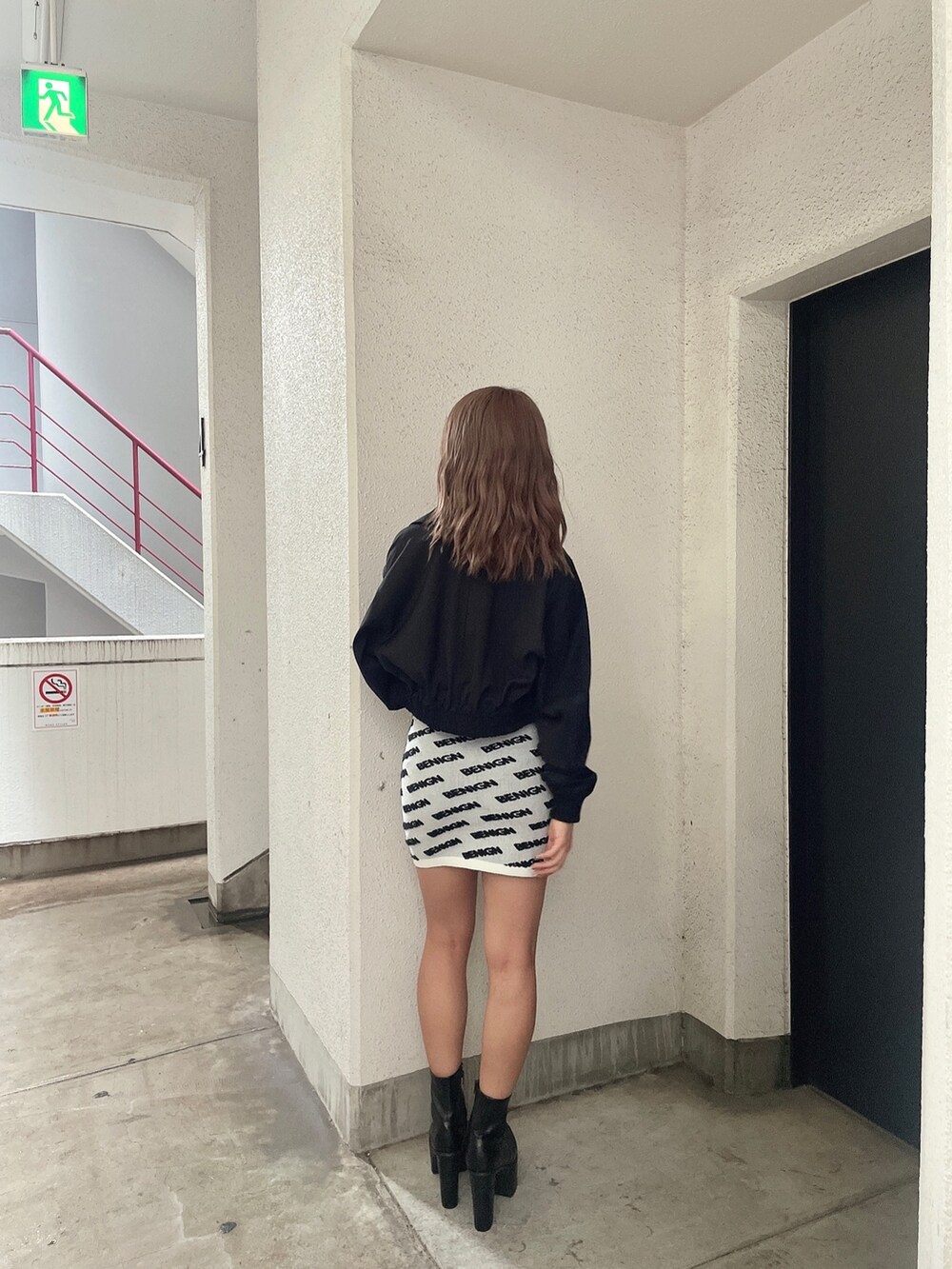 ホワイト系のワンピース、ブラック系のブルゾン、ブラック系のブーツを着用したレディースの夏コーディネートの3枚目の写真