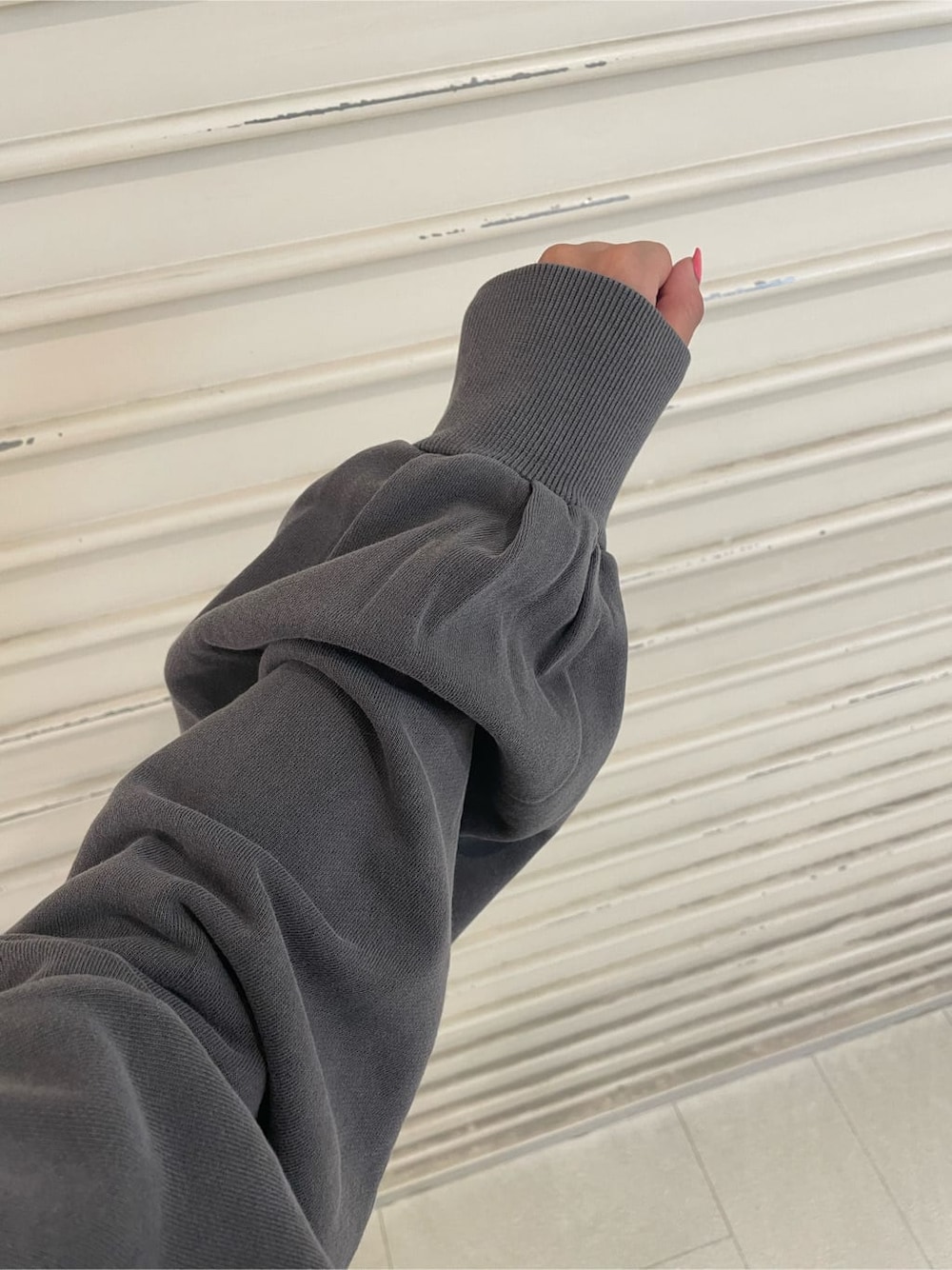 ブラック系のデニムパンツ、グレー系のスウェット、ブラック系のブーツを着用したレディースの秋コーディネートの8枚目の写真