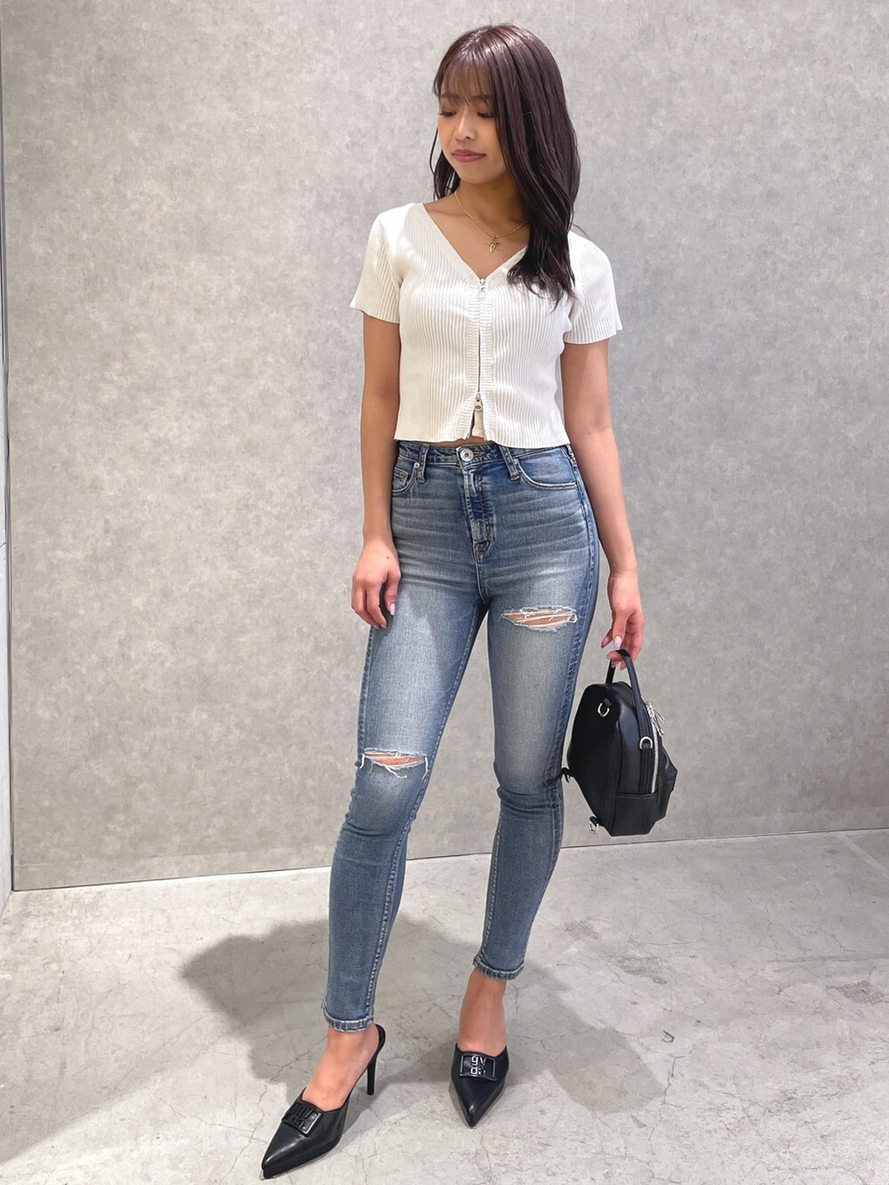 ホワイト系のTシャツ/カットソー、ブルー系のデニムパンツ、ブラック系のパンプスを着用したレディースの春コーディネートの2枚目の写真