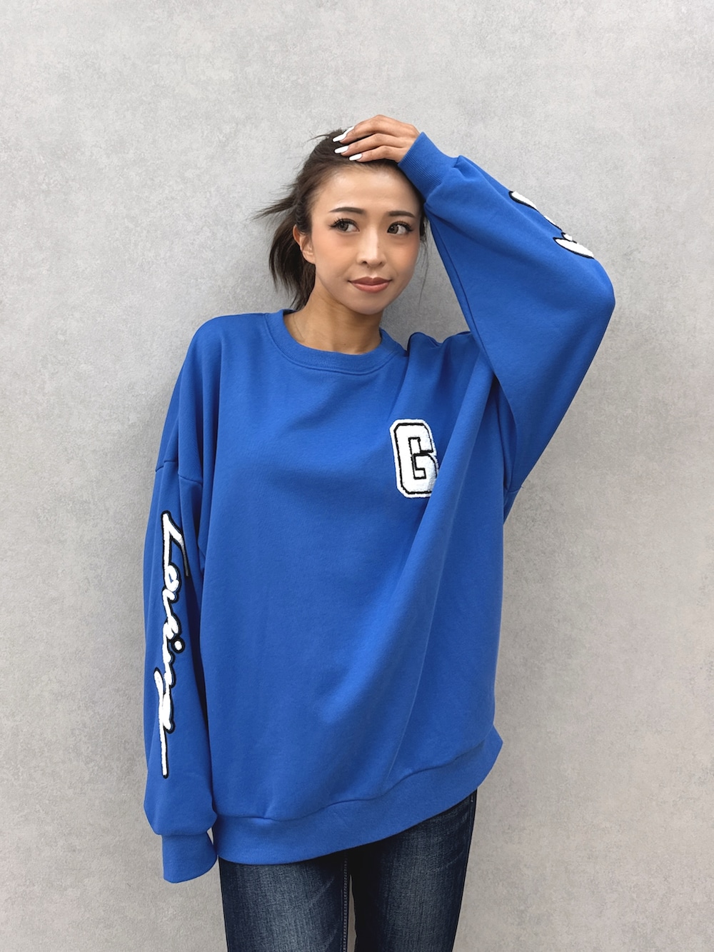 ブルー系のスウェット、ブルー系のデニムパンツ、ブラック系のブーツを着用したレディースの秋コーディネートの4枚目の写真