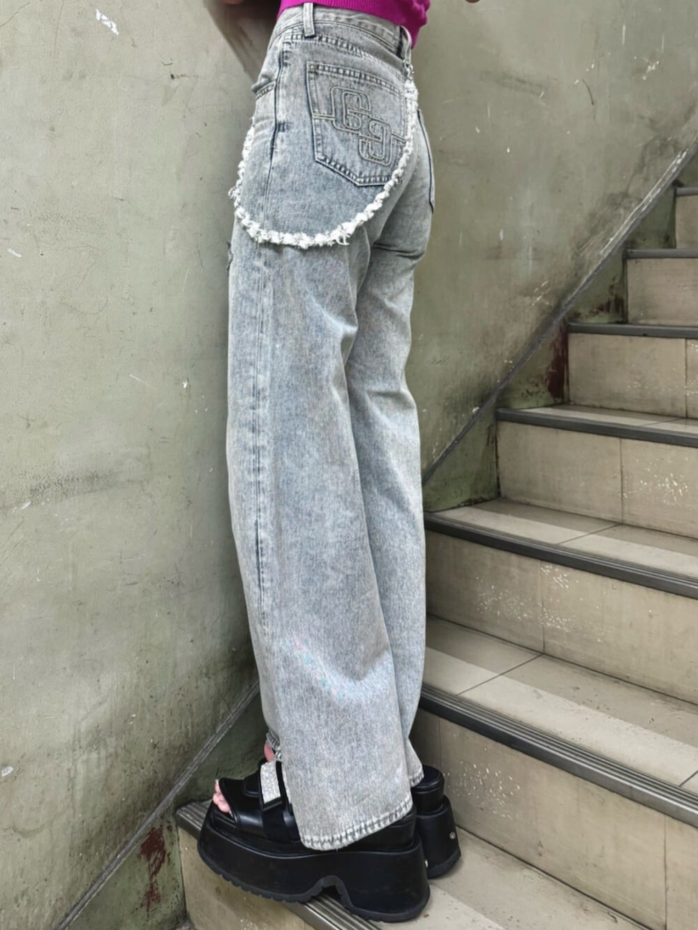 ブラック系のサンダル、ブルー系のデニムパンツ、ブラック系のチューブトップを着用したレディースの夏コーディネートの7枚目の写真