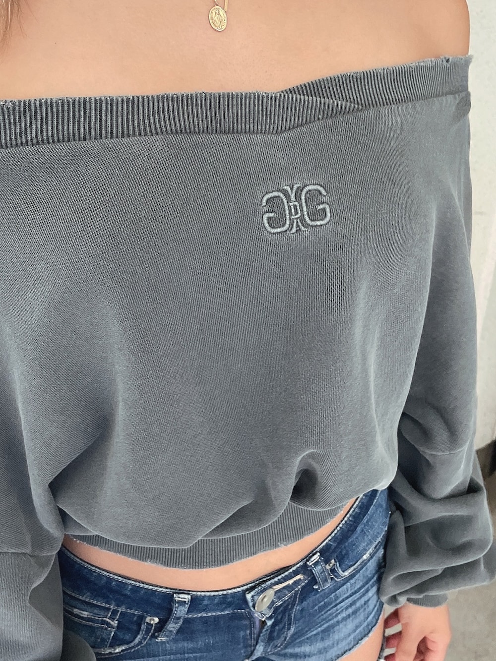 グレー系のスウェット、ブルー系のデニムパンツ、ブラック系のパンプスを着用したレディースの夏コーディネートの7枚目の写真