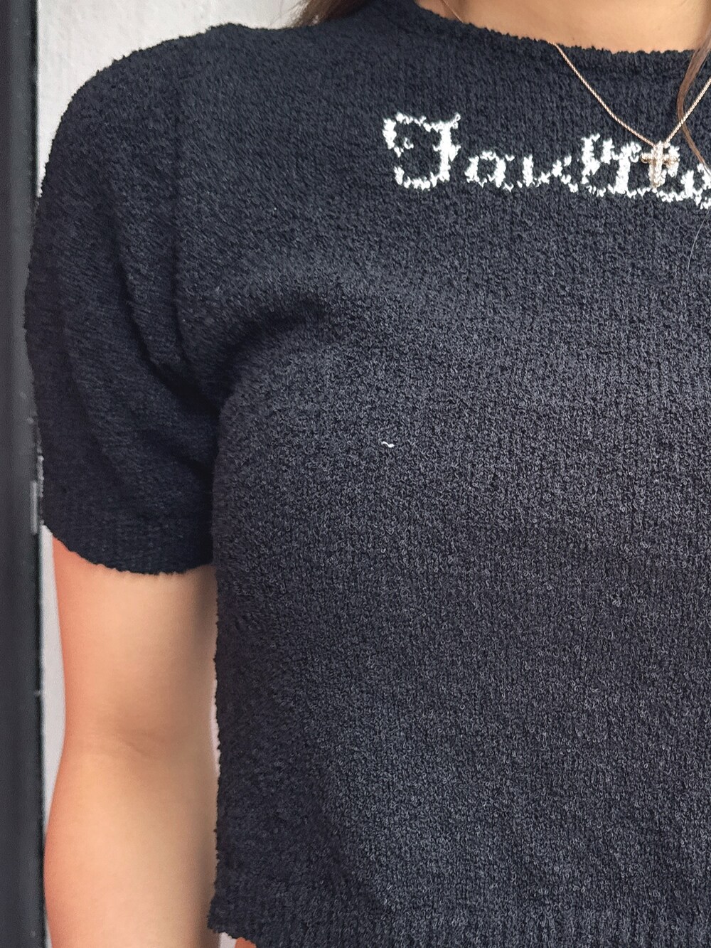 ブラック系のTシャツ/カットソー、ブラック系のデニムパンツ、ホワイト系のパンプスを着用したレディースの春コーディネートの7枚目の写真