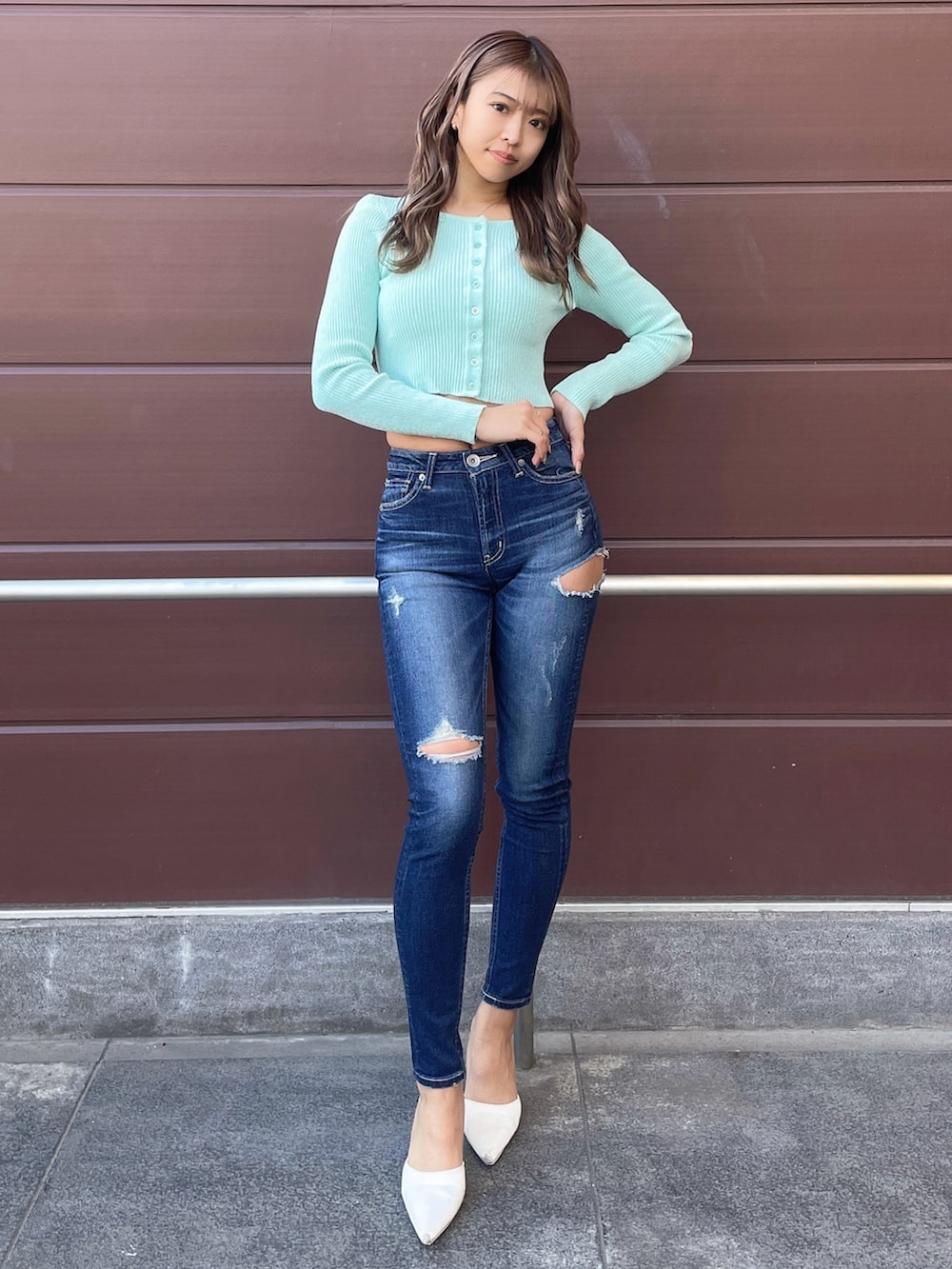 グリーン系のカーディガン/ボレロ、ブルー系のデニムパンツ、ホワイト系のパンプスを着用したレディースの冬コーディネートの2枚目の写真