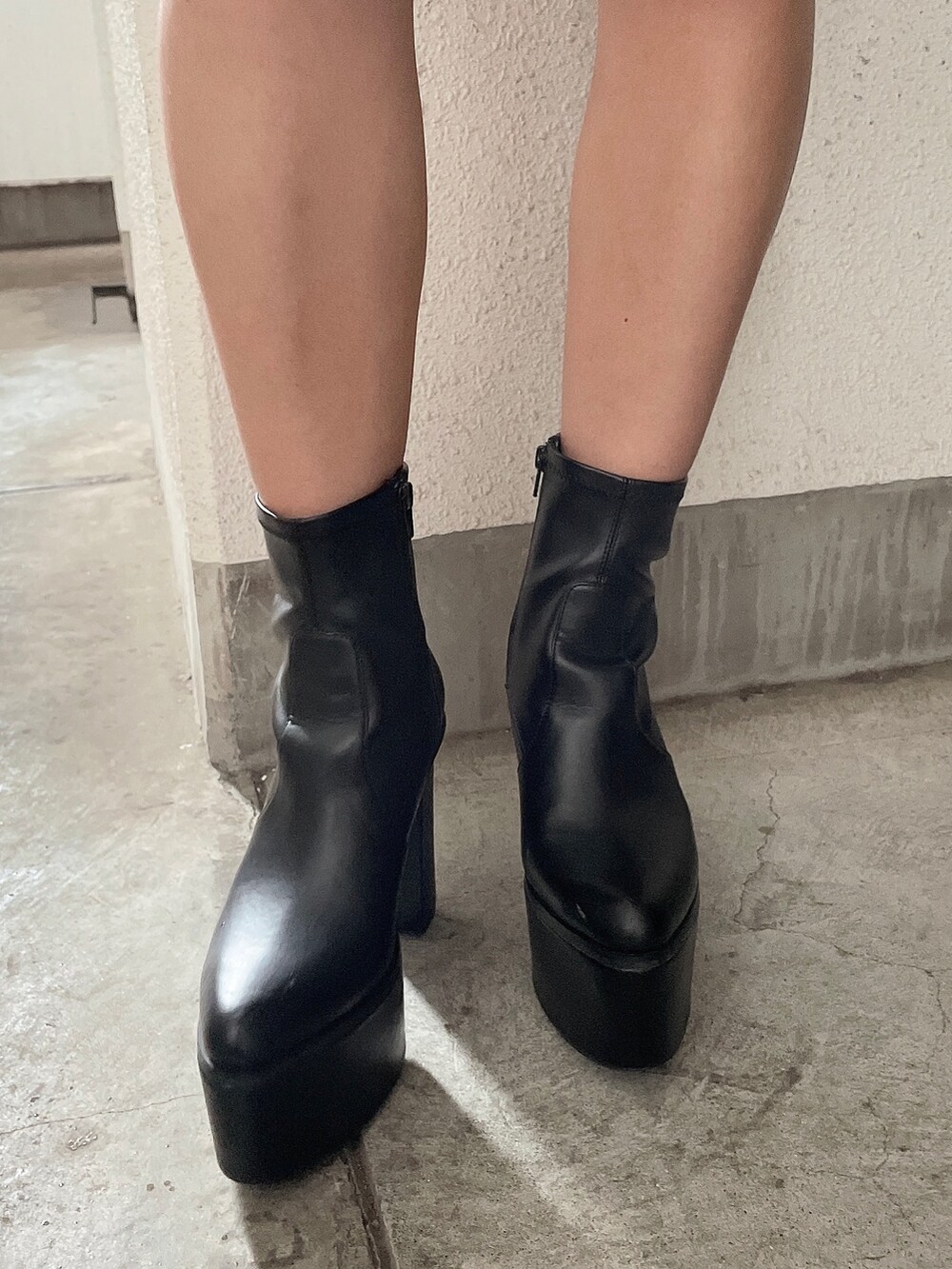 ホワイト系のワンピース、ブラック系のブーツを着用したレディースの夏コーディネートの5枚目の写真