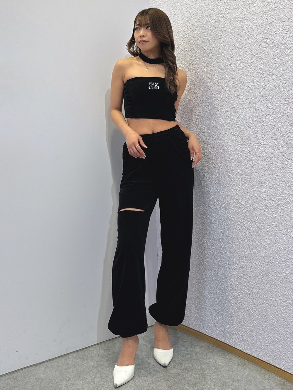 ブラック系のチューブトップ、ブラック系のその他パンツ、ホワイト系のパンプスを着用したレディースの春コーディネートの2枚目の写真