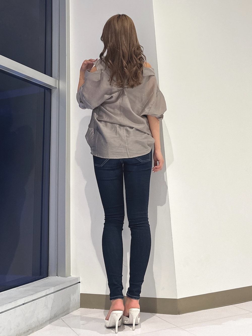 ベージュ系のシャツ/ブラウス、ブルー系のデニムパンツ、ホワイト系のパンプスを着用したレディースの春コーディネートの4枚目の写真