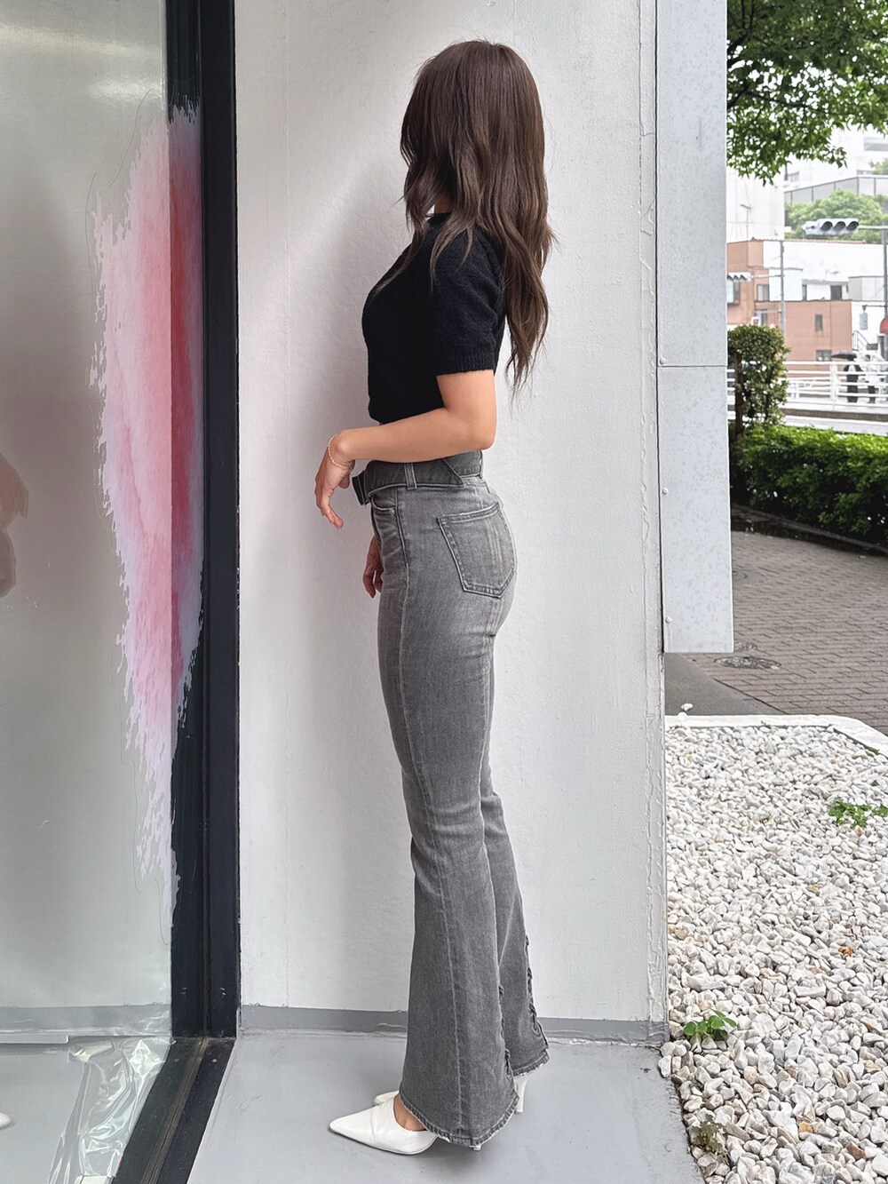 ブラック系のTシャツ/カットソー、ブラック系のデニムパンツ、ホワイト系のパンプスを着用したレディースの春コーディネートの2枚目の写真