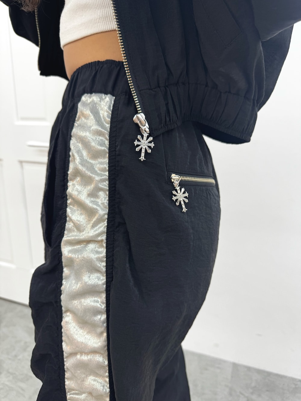 ホワイト系のチューブトップ、ブラック系のブルゾン、ブラック系のその他パンツを着用したレディースの春コーディネートの9枚目の写真