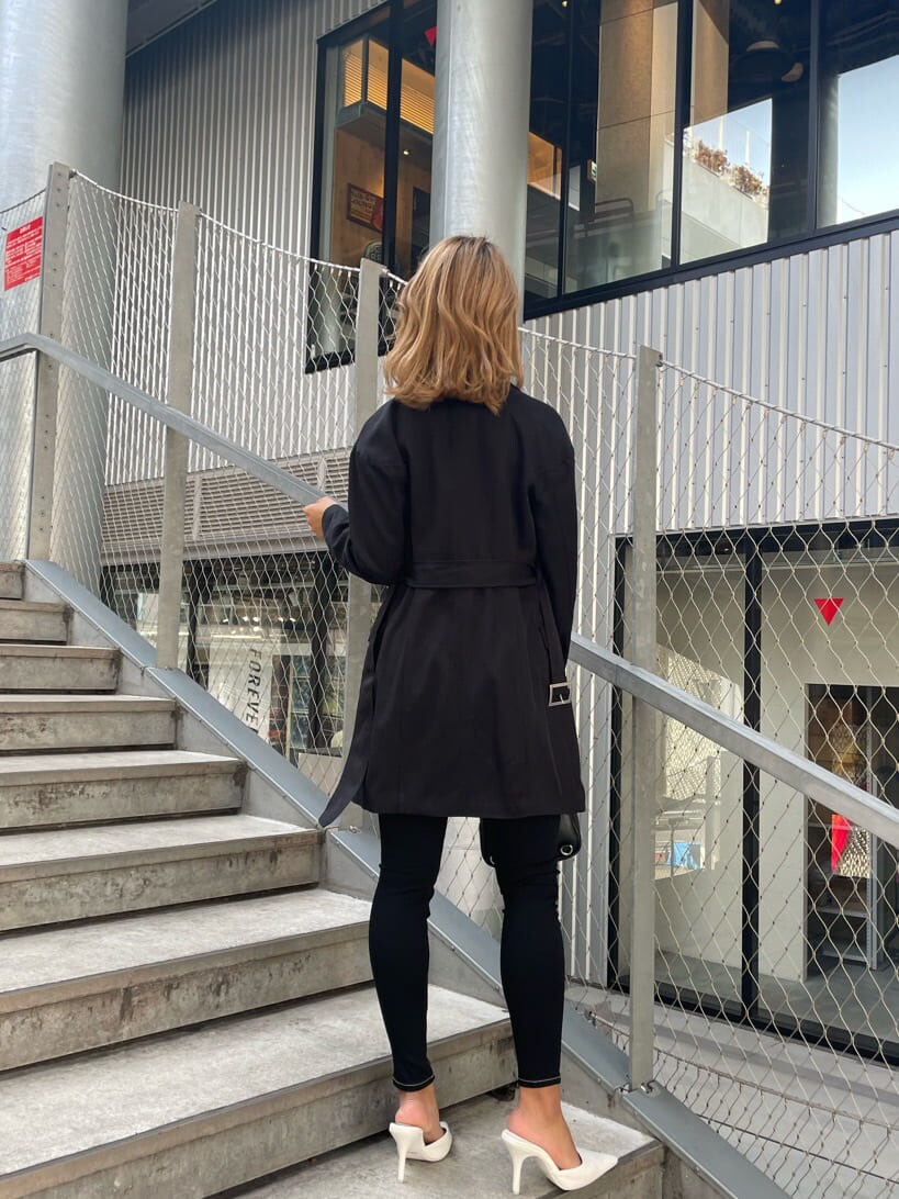 ホワイト系のチューブトップ、ブラック系のパンプス、ブラック系のデニムパンツを着用したレディースの春コーディネートの8枚目の写真