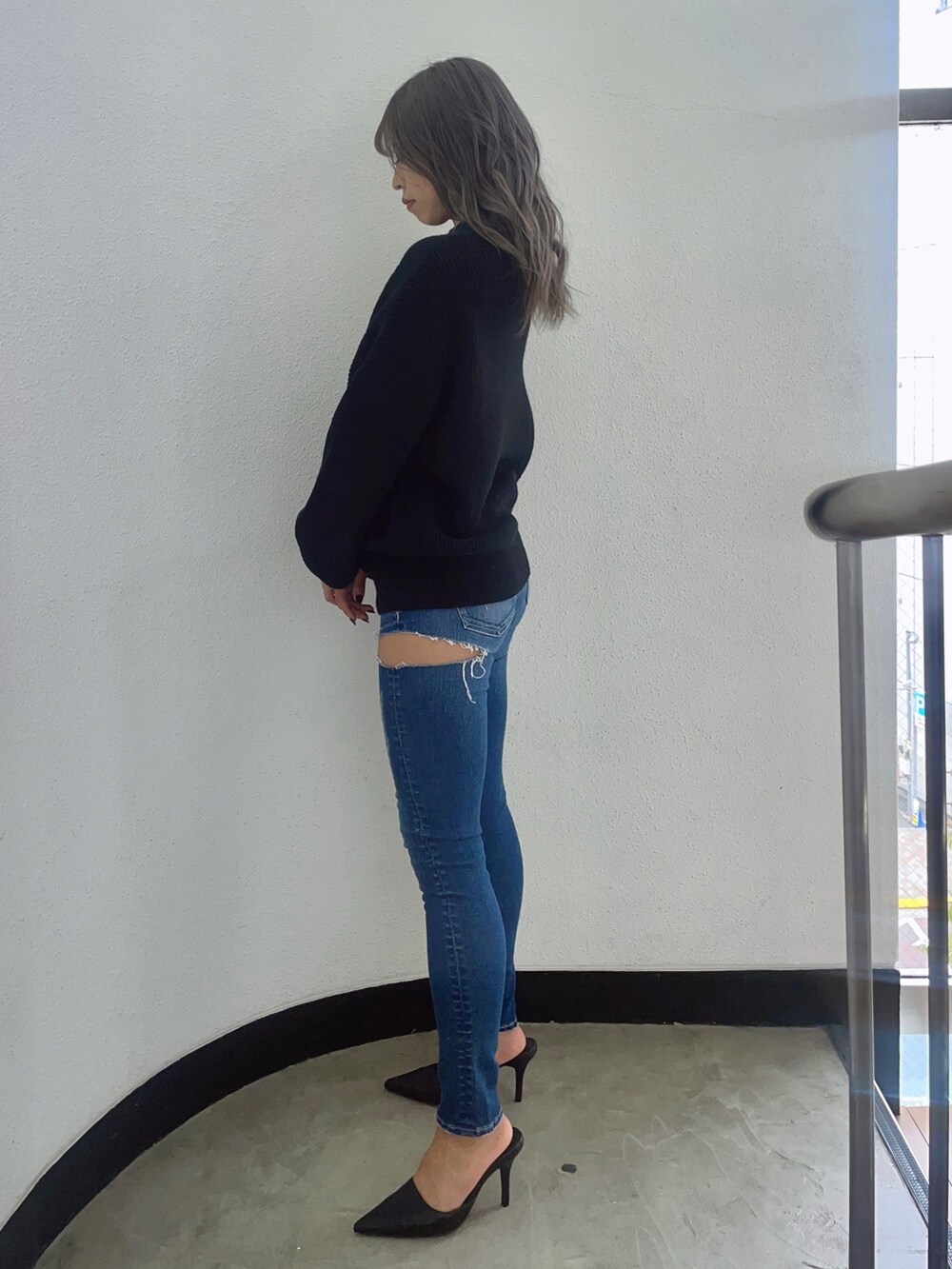 ブラック系のニット/セーター、ブルー系のデニムパンツ、ブラック系のパンプスを着用したレディースの秋コーディネートの3枚目の写真