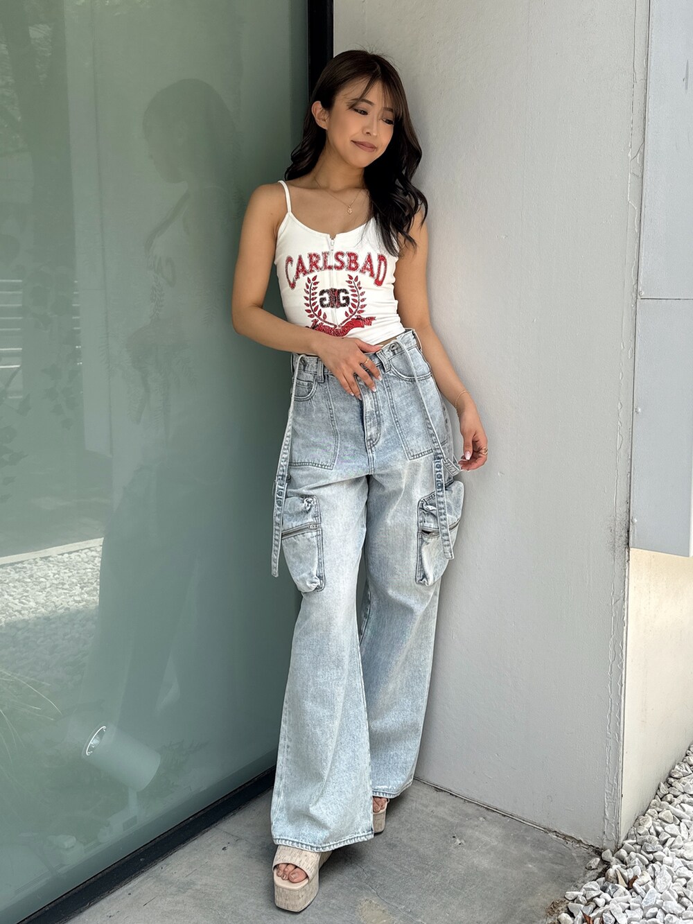 ホワイト系のキャミソール、ブルー系のデニムパンツ、ホワイト系のサンダルを着用したレディースの夏コーディネートの2枚目の写真