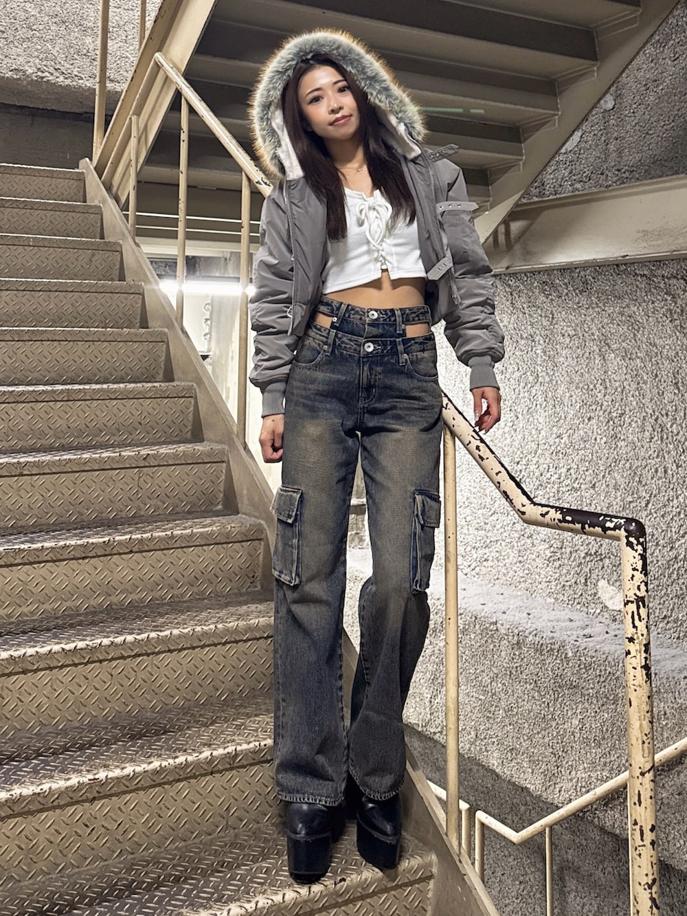 ホワイト系のTシャツ/カットソー、グレー系のブルゾン、ブルー系のデニムパンツを着用したレディースの秋コーディネートの2枚目の写真