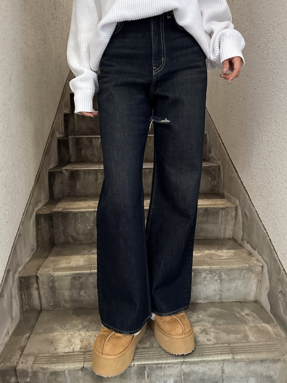 ホワイト系のニット/セーター、ブルー系のデニムパンツ、ベージュ系のスリッポンを着用したレディースの冬コーディネートの4枚目の写真