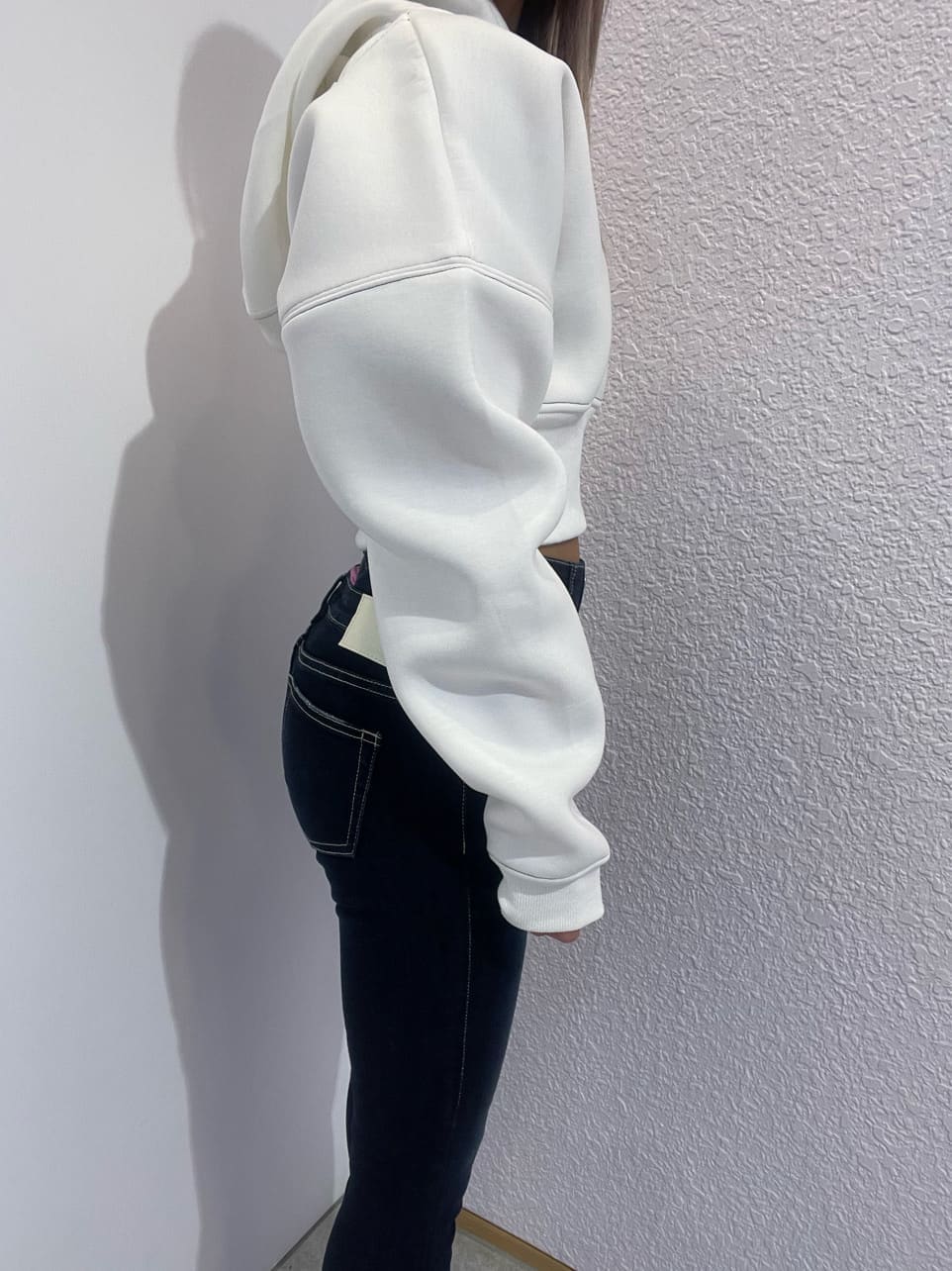 ブルー系のデニムパンツ、ホワイト系のパーカー、ブラック系のパンプスを着用したレディースの秋コーディネートの5枚目の写真