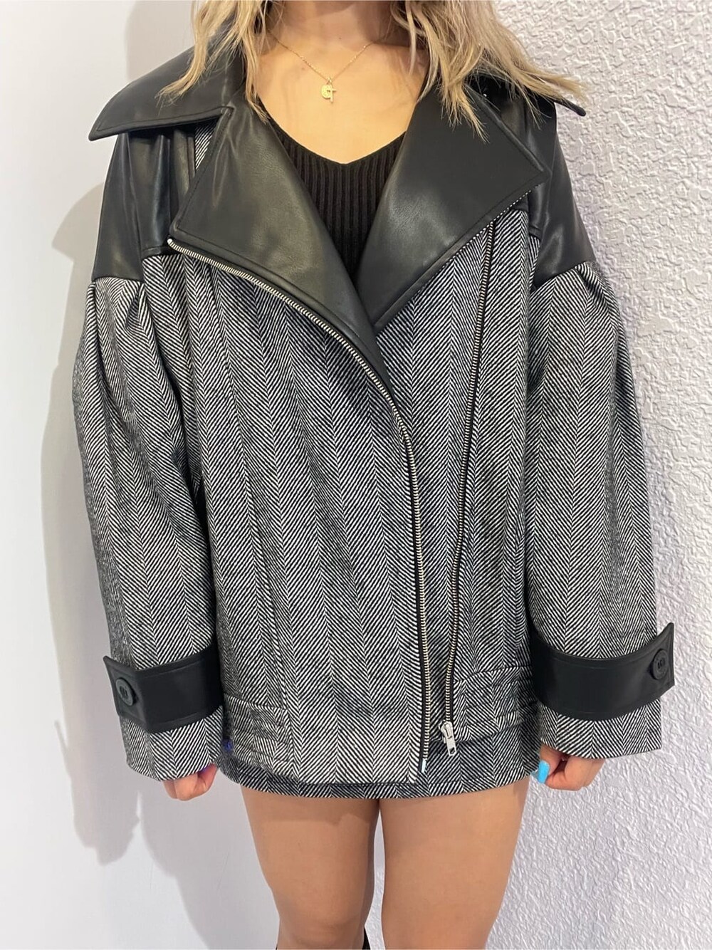 ブラック系のライダースジャケット、ブラック系のニット/セーター、ブラック系のスカートを着用したレディースの秋コーディネートの9枚目の写真