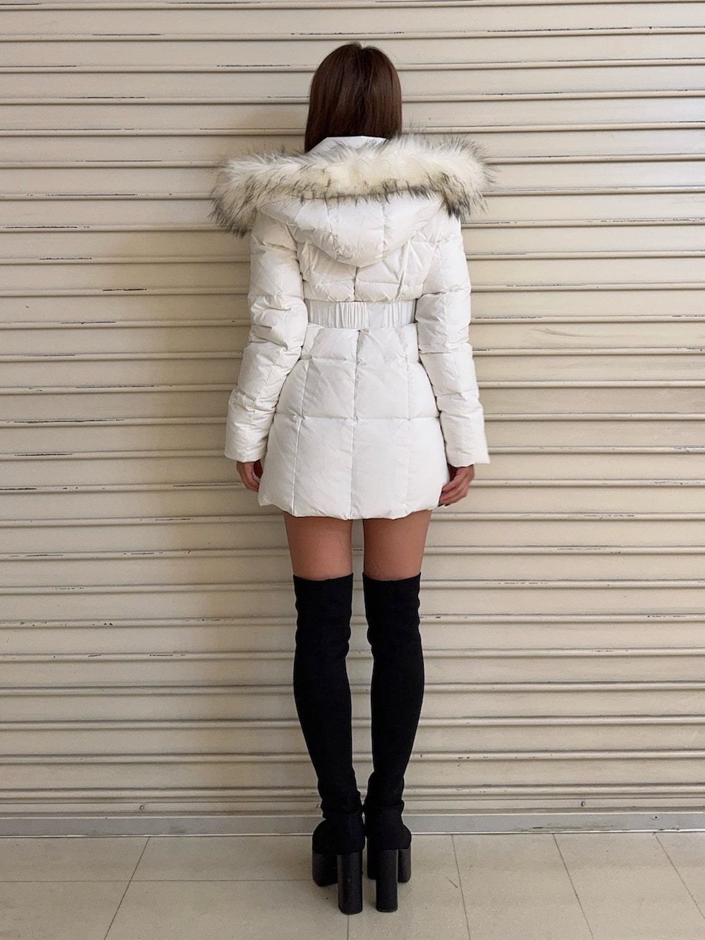 ブラック系のブーツ、ホワイト系のダウンジャケット/コート、ホワイト系のニット/セーターを着用したレディースの秋コーディネートの4枚目の写真