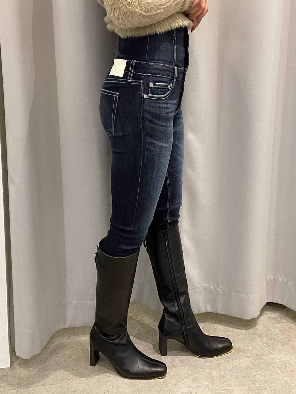 ブラック系のブーツ、ブルー系のパンツ、ブラック系のその他アウターを着用したレディースの秋コーディネートの9枚目の写真