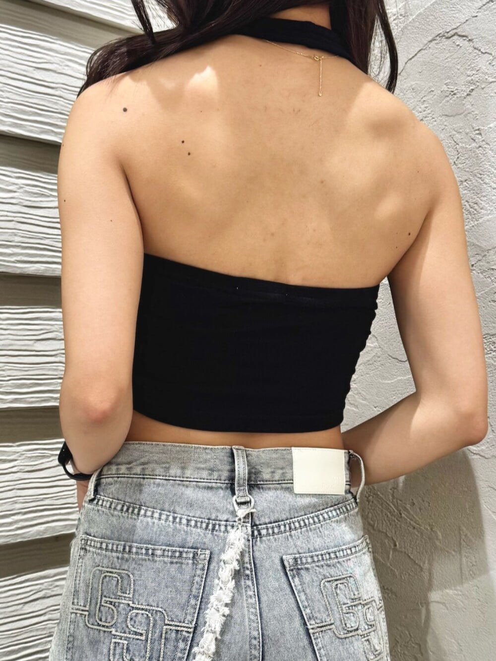 ブラック系のサンダル、ブルー系のデニムパンツ、ブラック系のチューブトップを着用したレディースの夏コーディネートの5枚目の写真