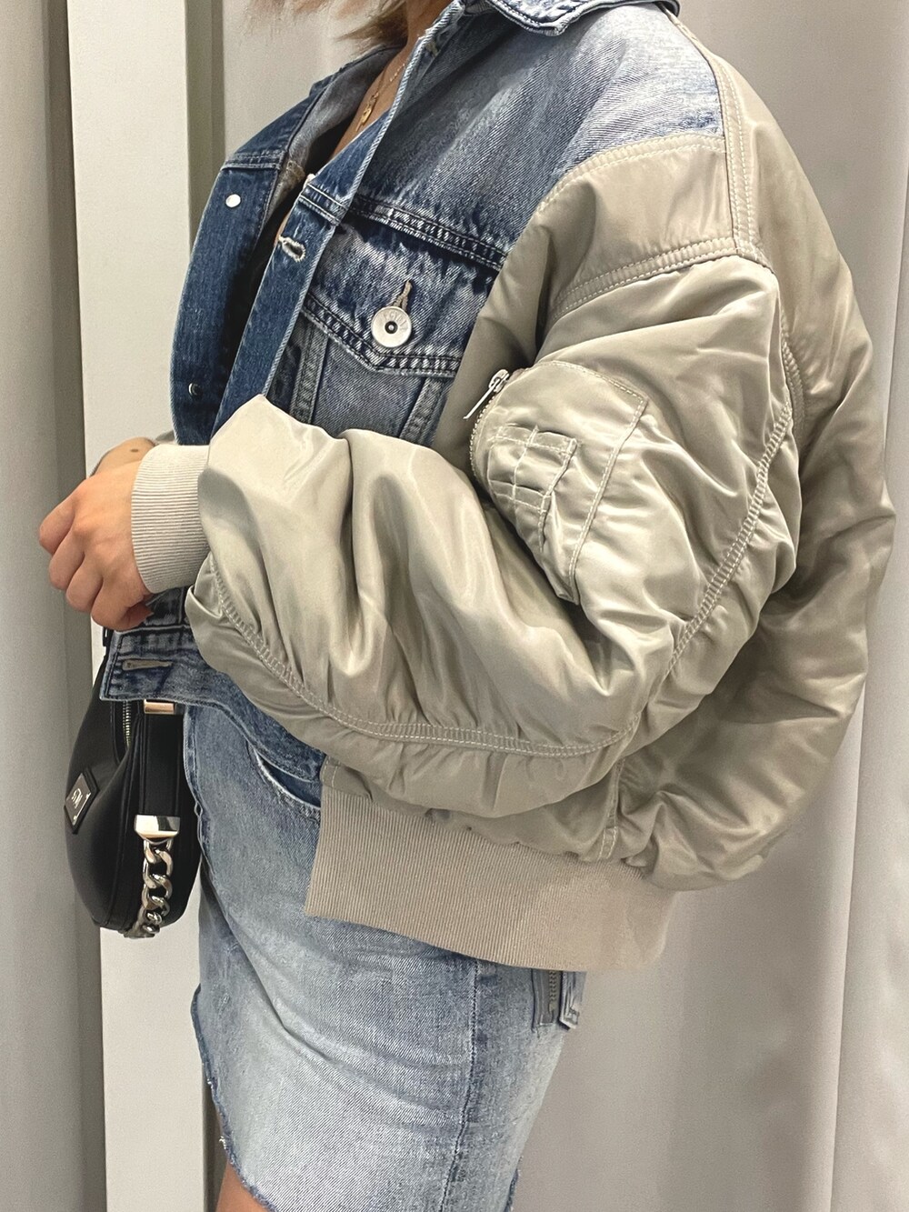 ブルー系のデニムジャケット、ブルー系のデニムスカート、ブラック系のチューブトップを着用したレディースの冬コーディネートの5枚目の写真