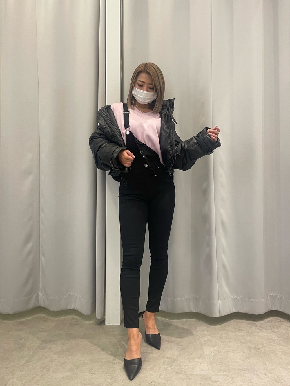 ブラック系のサロペット/オーバーオール、ピンク系のニット/セーター、ブラック系のダウンジャケット/コートを着用したレディースの冬コーディネートの3枚目の写真