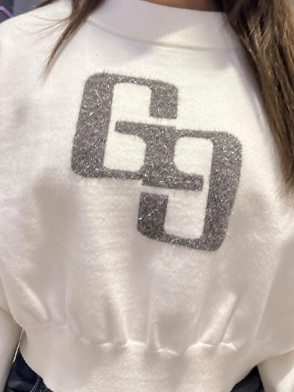 ホワイト系のニット/セーター、ブルー系のデニムパンツ、ブラック系のブーツを着用したレディースの秋コーディネートの5枚目の写真