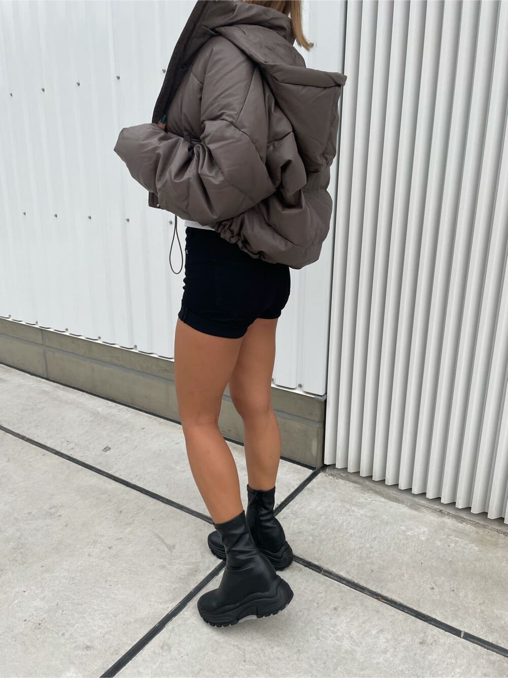 ベージュ系のダウンジャケット/コート、ブラック系のデニムパンツ、ブラック系のブーツを着用したレディースの秋コーディネートの5枚目の写真