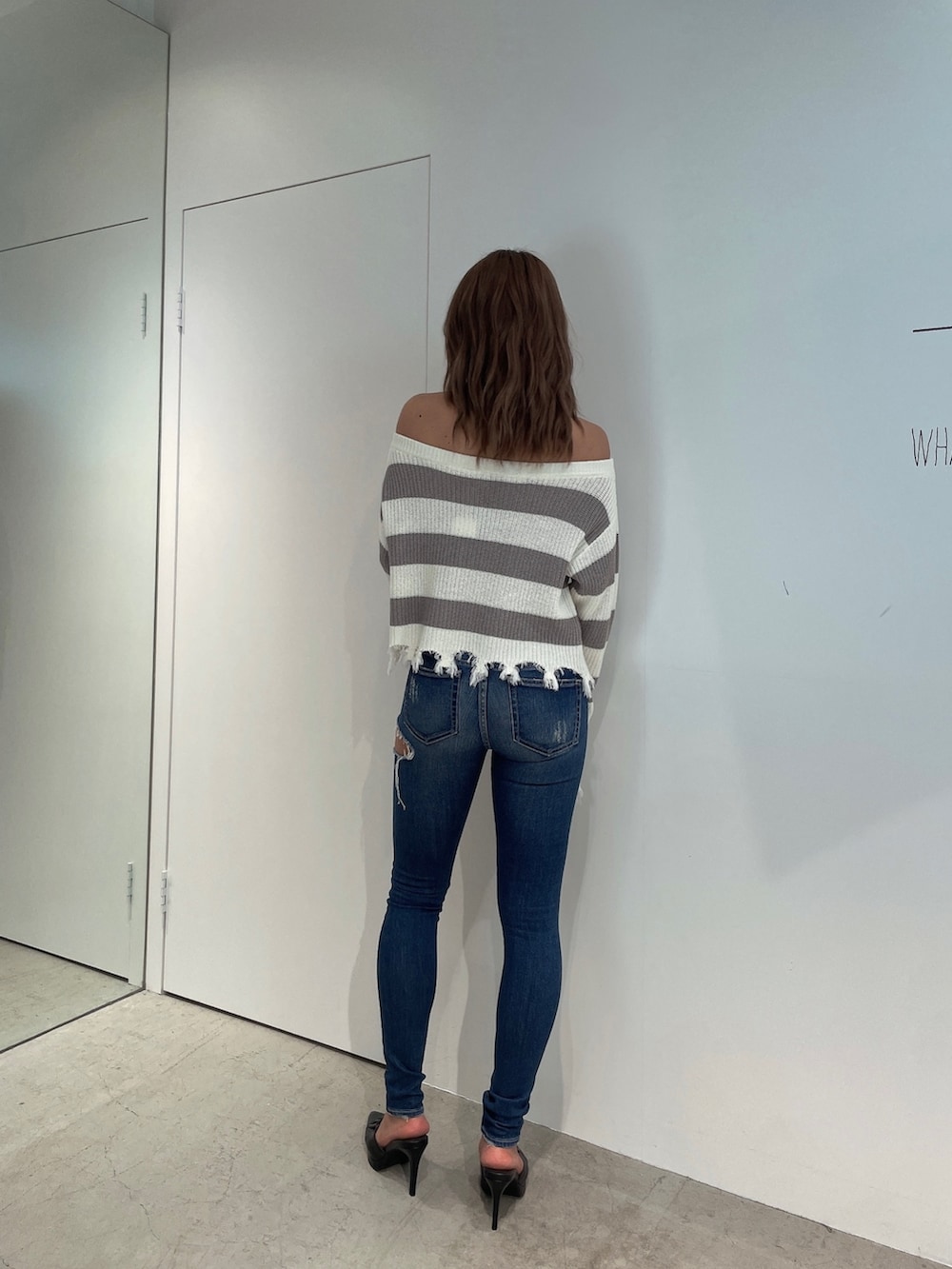 グレー系のニット/セーター、ブルー系のデニムパンツ、ブラック系のパンプスを着用したレディースの夏コーディネートの3枚目の写真