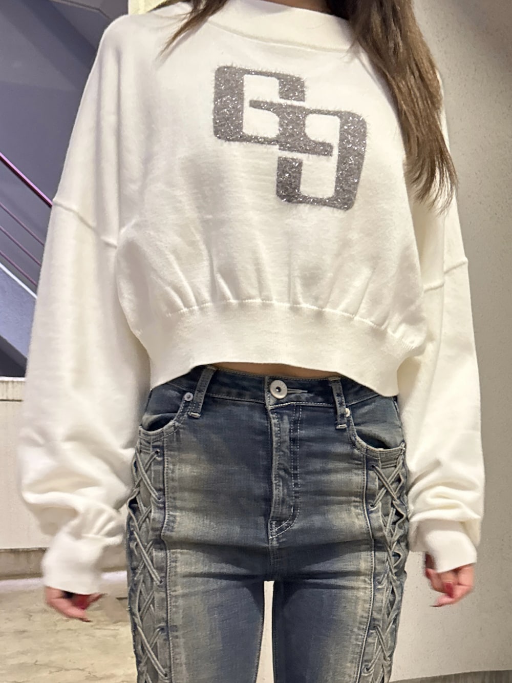 ホワイト系のニット/セーター、ブルー系のデニムパンツ、ブラック系のブーツを着用したレディースの秋コーディネートの4枚目の写真