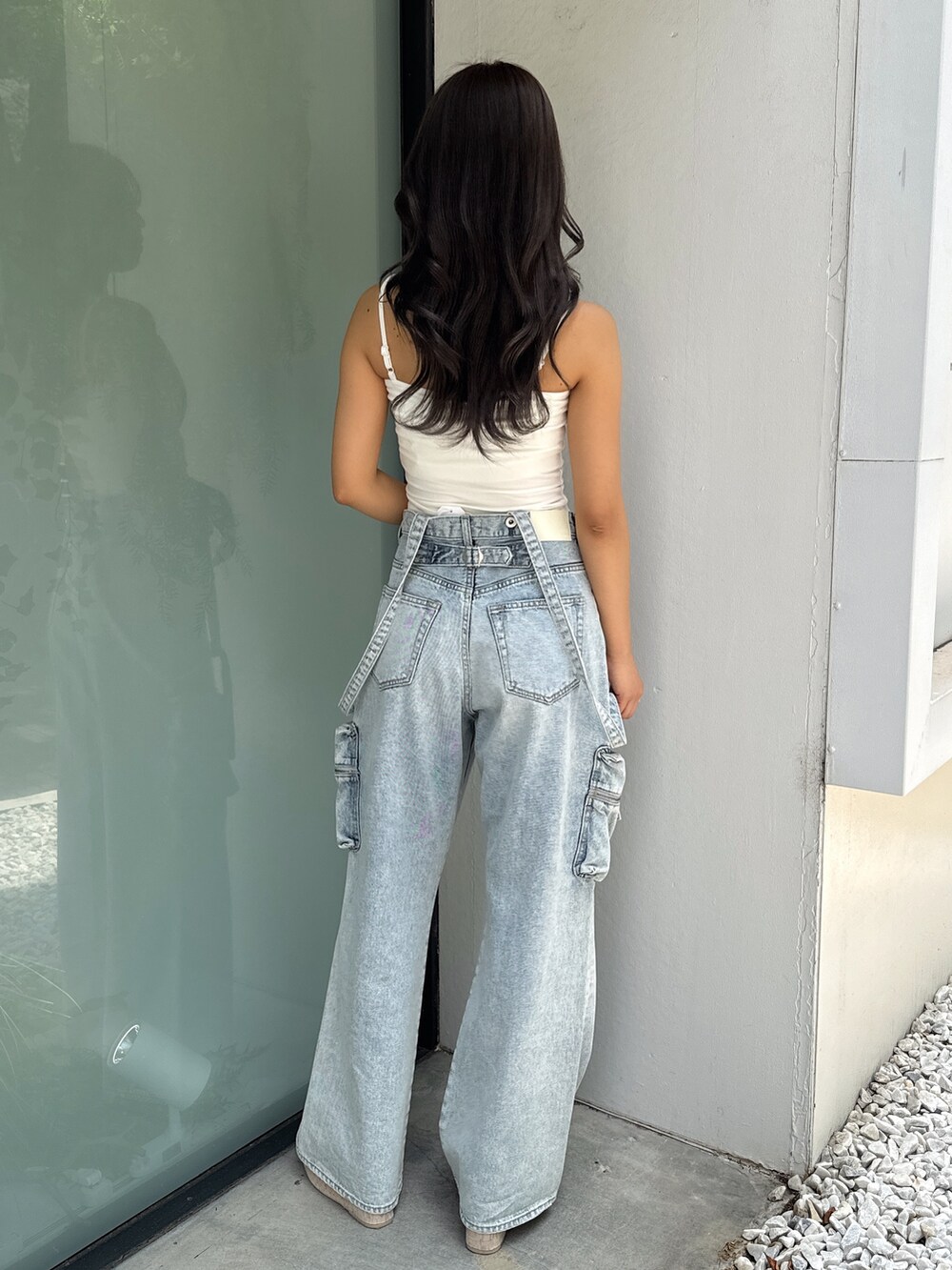 ホワイト系のキャミソール、ブルー系のデニムパンツ、ホワイト系のサンダルを着用したレディースの夏コーディネートの4枚目の写真