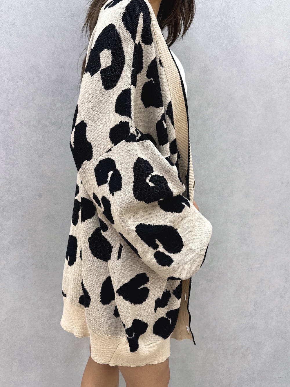 ホワイト系のチューブトップ、ベージュ系のカーディガン/ボレロ、ブルー系のデニムパンツを着用したレディースの夏コーディネートの6枚目の写真