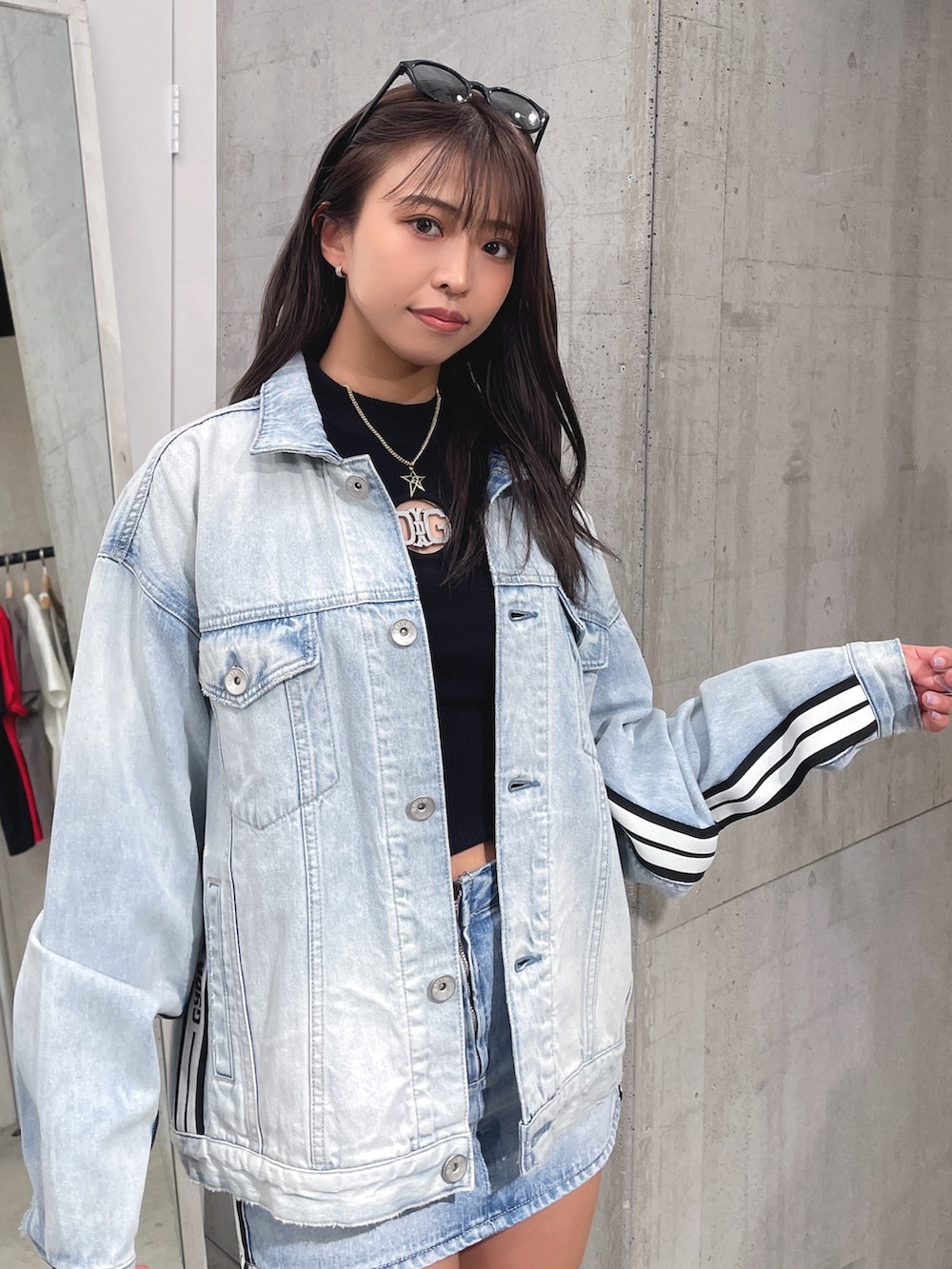 ブルー系のデニムスカート、ブラック系のブーツ、ブラック系のTシャツ/カットソーを着用したレディースの春コーディネートの6枚目の写真