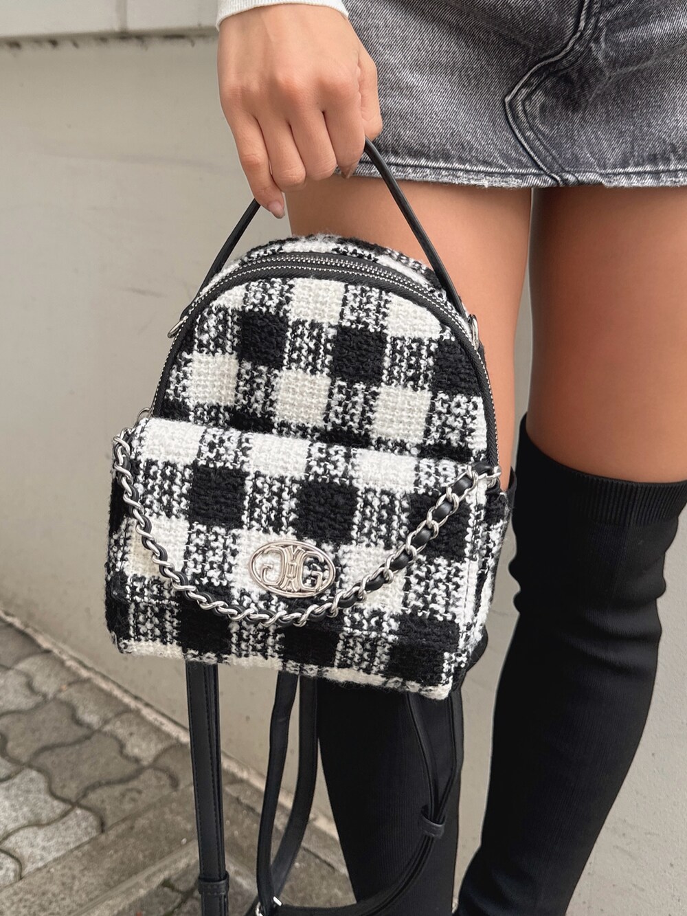 ホワイト系のニット/セーター、ブラック系のデニムスカート、その他のバックパック/リュックを着用したレディースの秋コーディネートの6枚目の写真