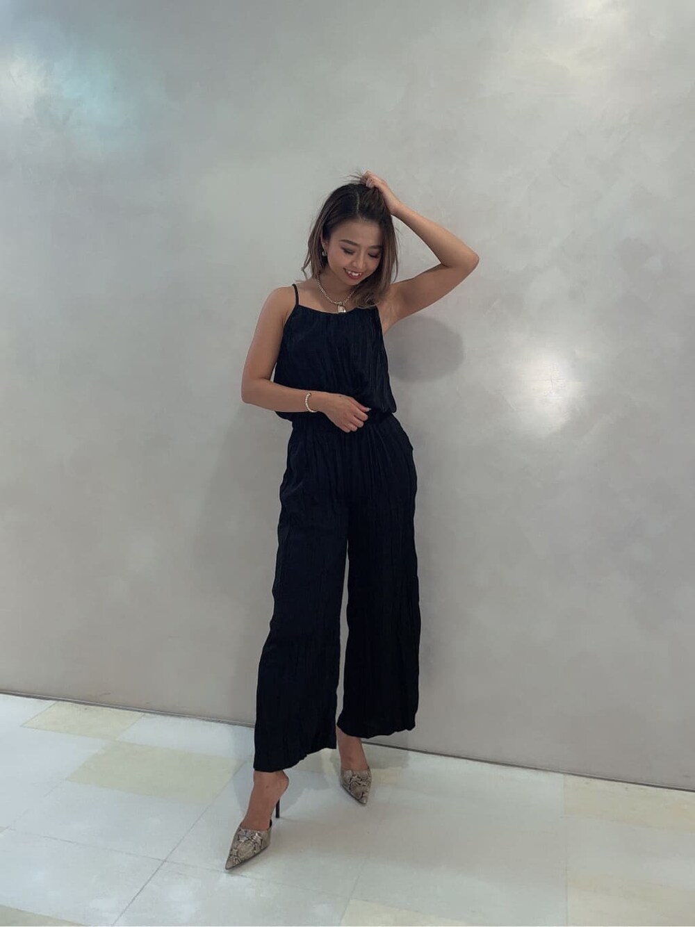 その他のパンプス、ブラック系のつなぎ/オールインワン、ゴールド系のネックレスを着用したレディースの夏コーディネートの2枚目の写真