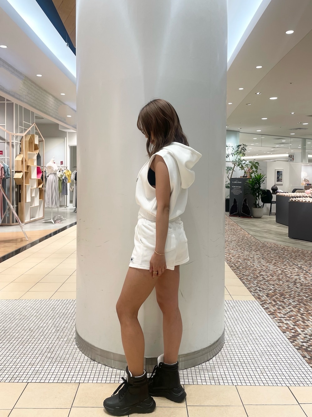 ホワイト系のパーカー、ホワイト系のスウェットパンツ、ブラック系のスニーカーを着用したレディースの夏コーディネートの3枚目の写真