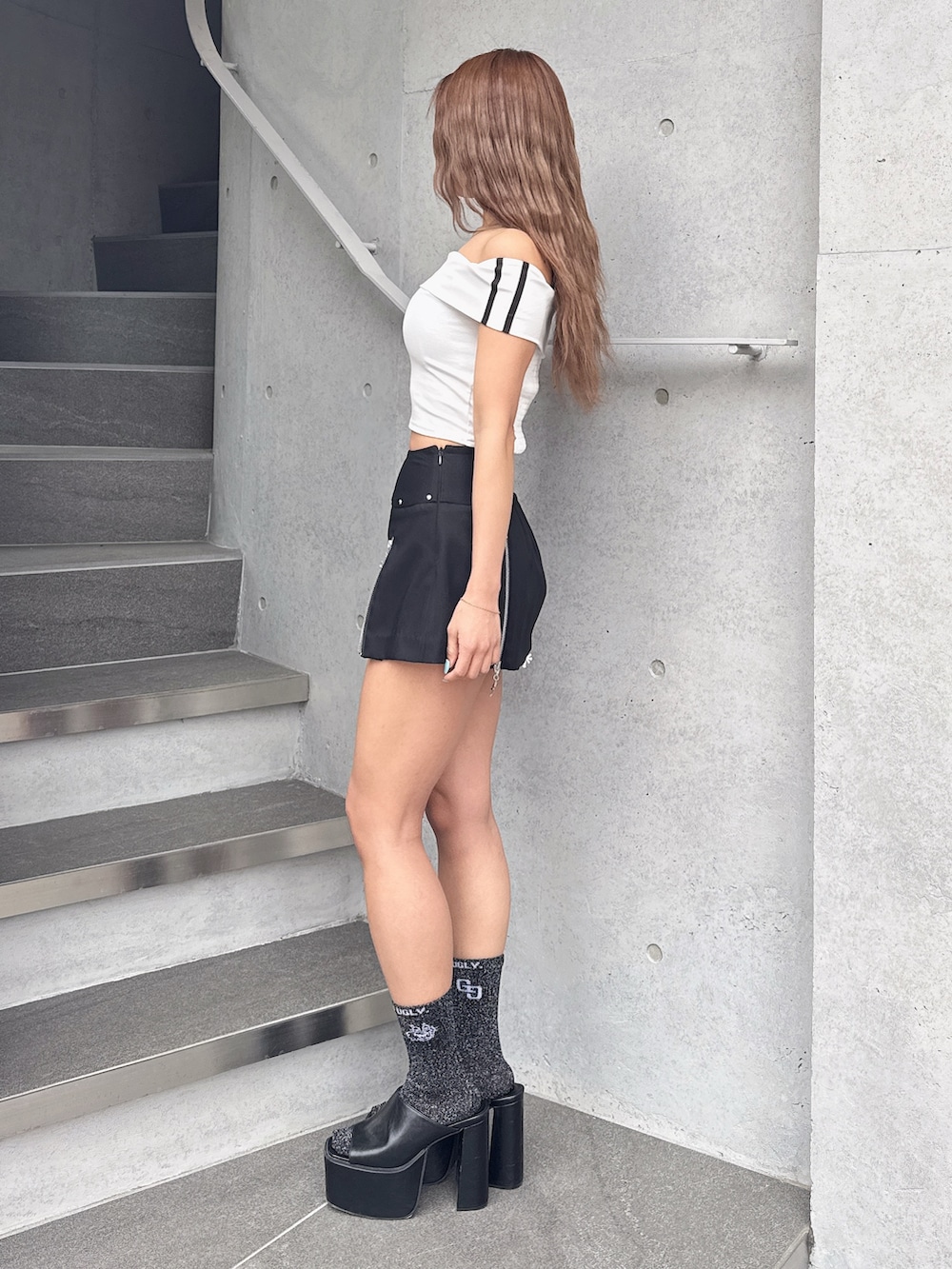 ホワイト系のTシャツ/カットソー、ブラック系のスカート、ブラック系のサンダルを着用したレディースの春コーディネートの3枚目の写真