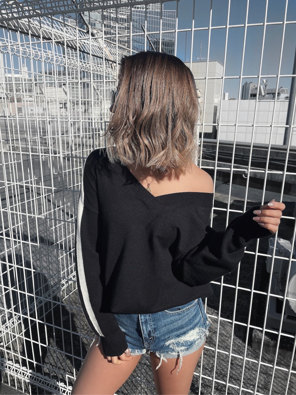 ブラック系のニット/セーター、ブルー系のデニムパンツを着用したレディースの冬コーディネートの2枚目の写真