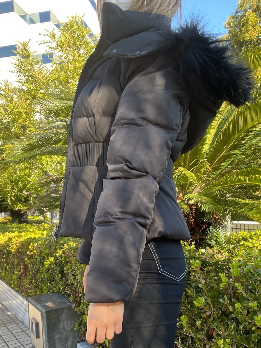 ブラック系のデニムパンツ、ブラック系のニット/セーター、ブラック系のその他アウターを着用したレディースの冬コーディネートの4枚目の写真