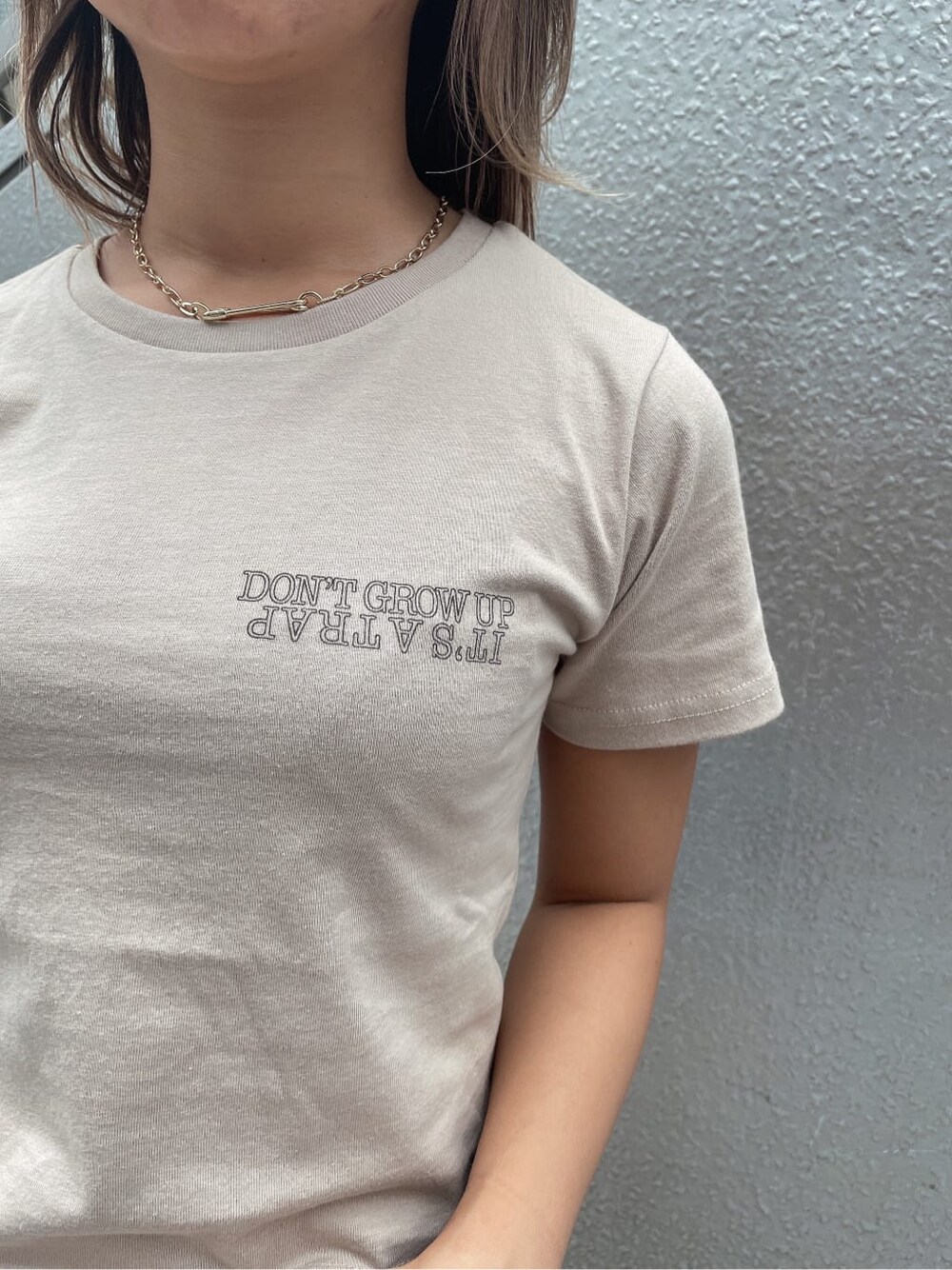 ブルー系のデニムパンツ、ホワイト系のハンドバッグ、ベージュ系のTシャツ/カットソーを着用したレディースの夏コーディネートの5枚目の写真