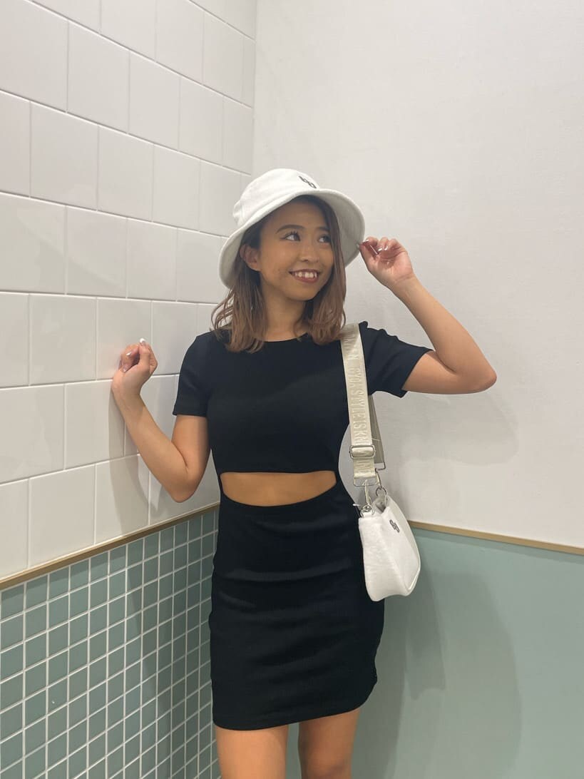 ブラック系のワンピース、ブラック系のサンダル、ホワイト系のハンドバッグを着用したレディースの春コーディネートの2枚目の写真