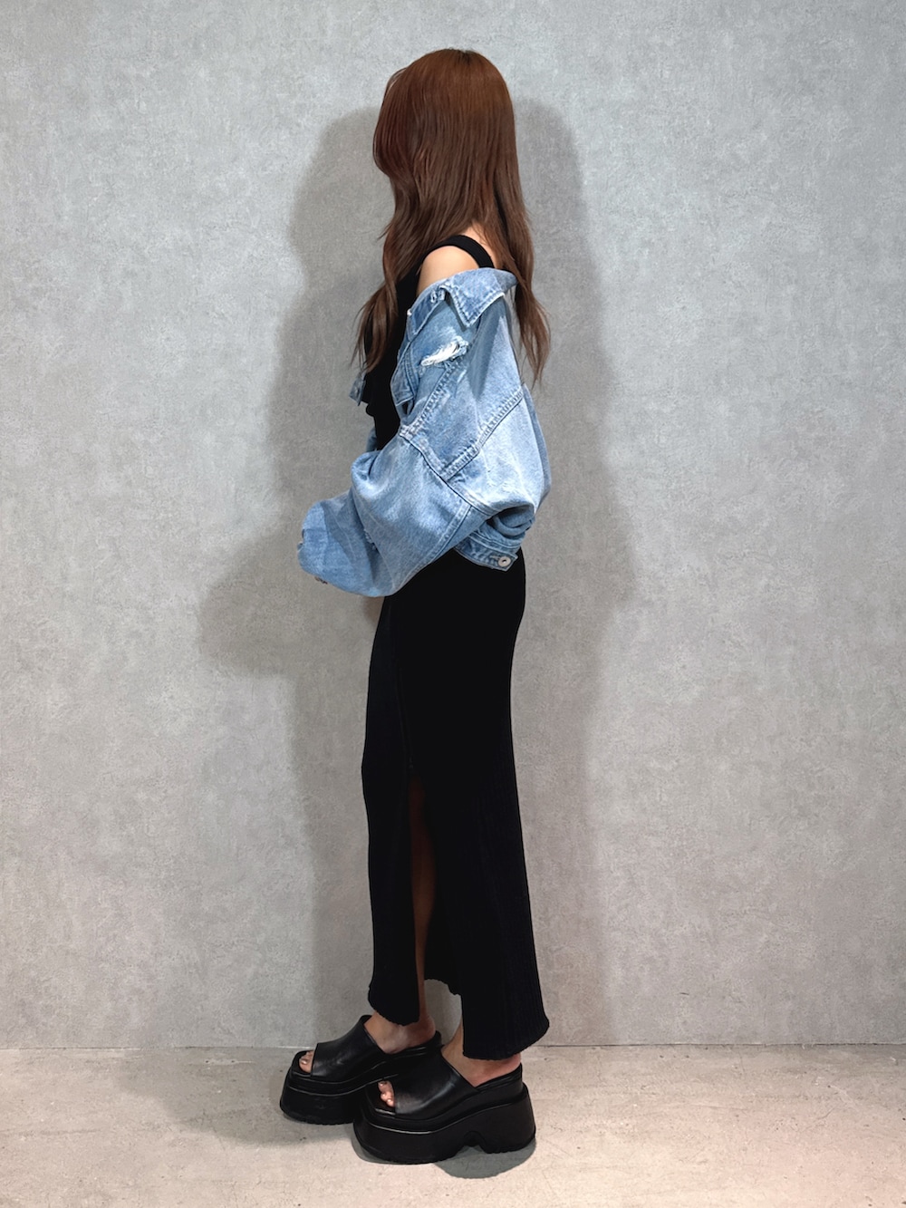 ブラック系のワンピース、ブルー系のデニムジャケット、ブラック系のサンダルを着用したレディースの春コーディネートの3枚目の写真